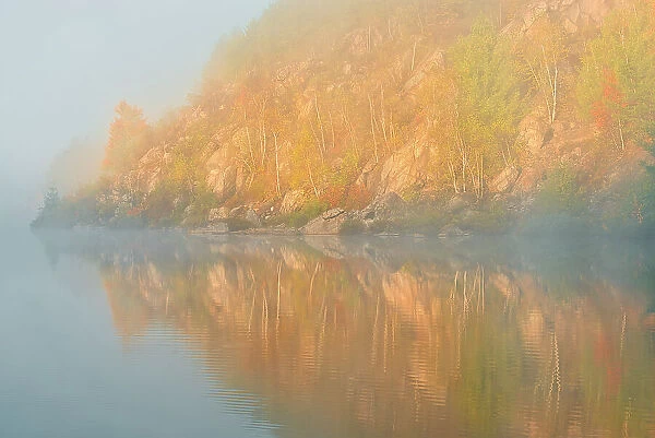 Autumn colors reflected in Lake Laurentian on an early foggy morning Sudbury, Ontario, Canada