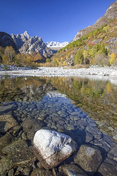 The autumn colors are reflected in Masino creek which creates a tranquil basin near