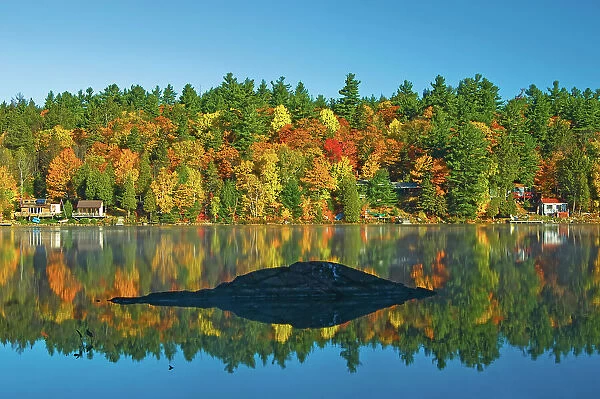 autumn colors on Tyson Lake with cottages Killarney District, Ontario, Canada