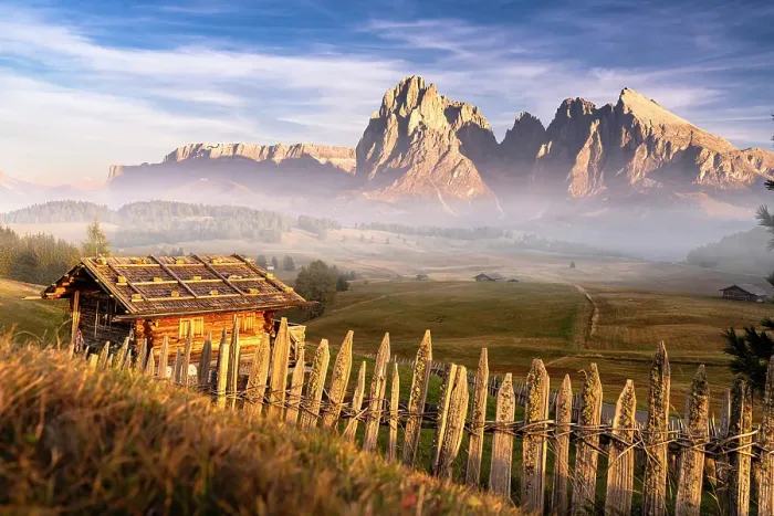 Framed Print : Autumn mist over Sassolungo and Sassopiatto and traditional huts at Seiser Alm plateau, Dolomites, South Tyrol, Italy