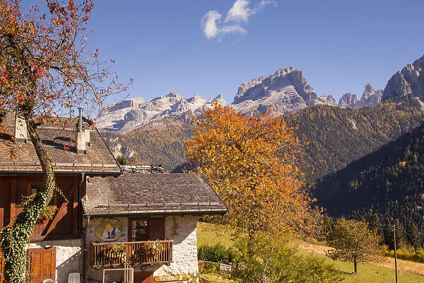 Autumnal landscape of a mountain house with Brenta Dolomites in background