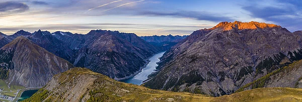 Autumnal sunset over Pizzo del Ferro peak and lake of Livigno, aerial view