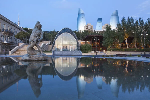 Azerbaijan, Baku, Flame Towers and entrance to Funicular railway reflecting in Bharam