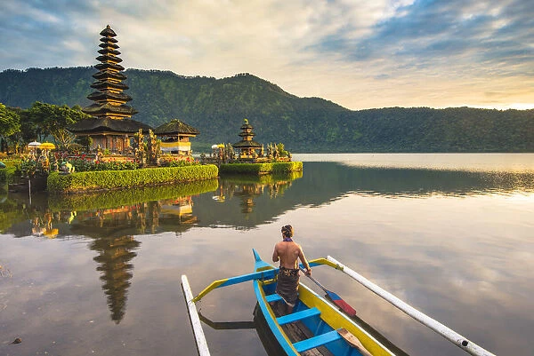 Bali, Indonesia, South East Asia. Balinese man with traditional clothes paddling an