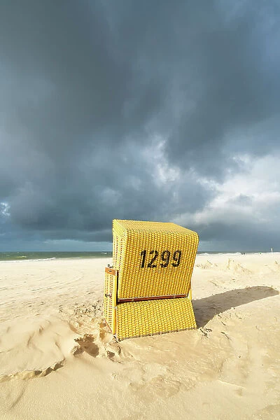 Beach chair against cloudy dramatic sky, Wenningstedt beach, Sylt, Nordfriesland, Schleswig-Holstein, Germany