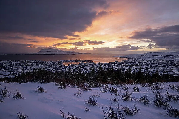 A beautiful view of Torshavn covered by snow at sunrise. In the background the island of Nolsoy. Island of Streymoy. Faroe Islands