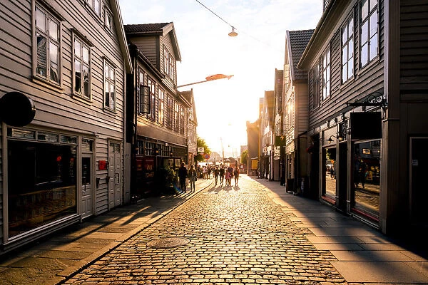 Bergen, Hordaland, Norway. Tourists walking in the old town at sunset
