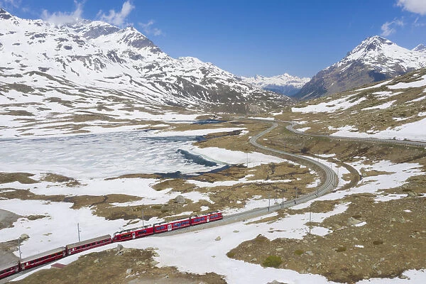 Bernina Express train at Lago Bianco during thaw, Bernina Pass, canton of Graubunden