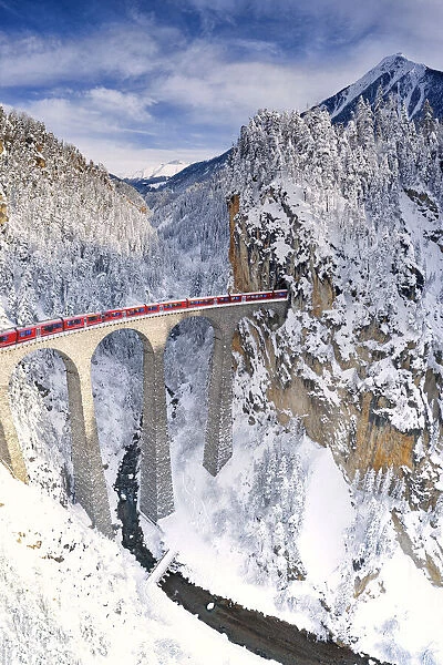Bernina Express train on Landwasser viaduct during the snowy winter, Filisur