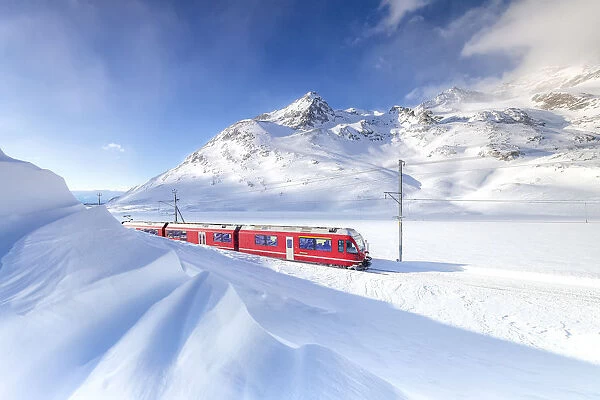 Bernina Express transit along Lago Bianco during winter blizzard, Bernina Pass, Engadin