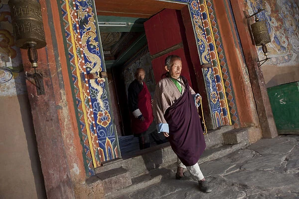 Bhutan. A monk walking through a doorway at the Gangtey Gompa