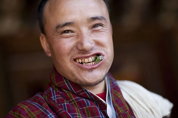 A Bhutanese man in a Gho eating Betel nut in Bhutan
