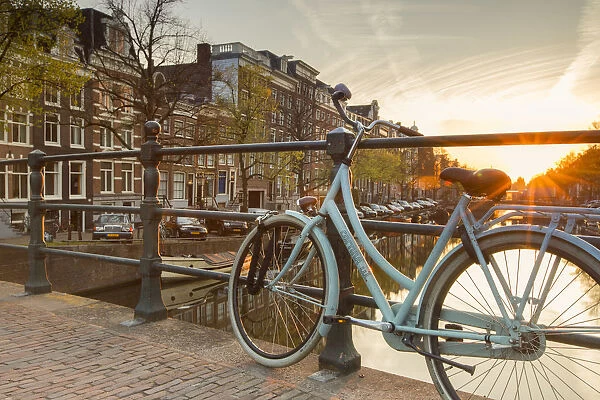 Bicycle on Keizersgracht canal at dawn, Amsterdam, Netherlands