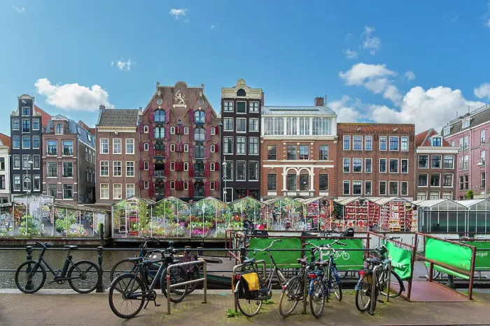 Framed Print : Bicycles standing against typical houses and floating flower market near Singel canal, Amsterdam, Netherlands Framed Print : Bicycles standing against typical houses and floating flower market near Singel canal, Amsterdam, Netherlands