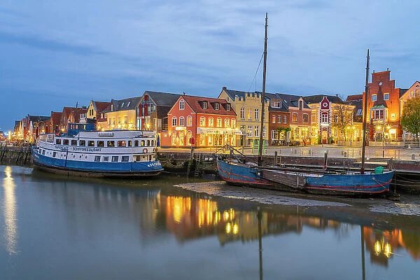 Binnenhafen port with anchored boats and colorful houses at twilight, Husum, Nordfriesland, Schleswig-Holstein, Germany