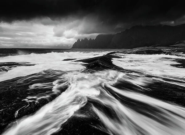 A black and white perspective of the rugged Okshornan peaks seen from Tungeneset on a stormy evening. Senja Island, Norway