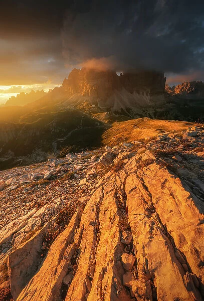 A blazing sunset light over the south face of the Tre Cime di Lavaredo after a passing storm. Dolomites, Italy