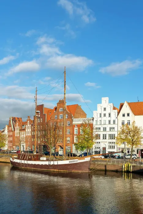 Framed Print : Boat anchored on Trave river and houses with traditional gables in background, Lubeck, UNESCO, Schleswig-Holstein, Germany