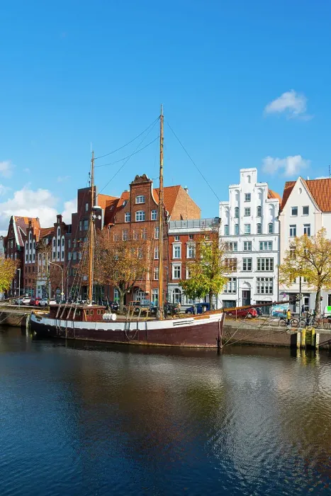Framed Print : Boat anchored on Trave river and houses with traditional gables in background, Lubeck, UNESCO, Schleswig-Holstein, Germany Framed Print : Boat anchored on Trave river and houses with traditional gables in background, Lubeck, UNESCO, Schleswig-Holstein, Germany