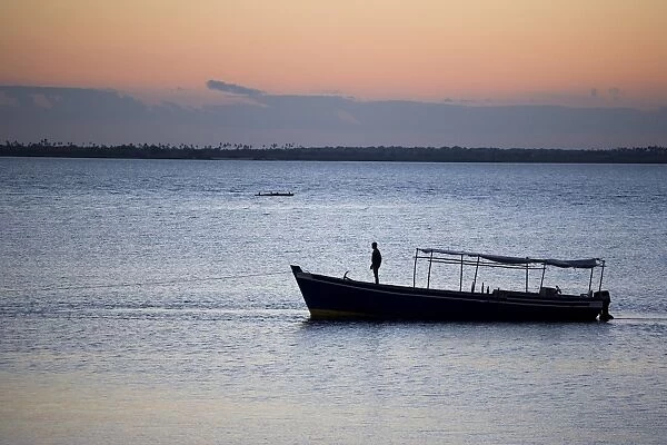 A boat arrives at the Ilha do Mozambique at sunset