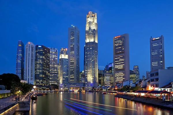Boat Quay and the Singapore River with the Financial District illuminated at dusk