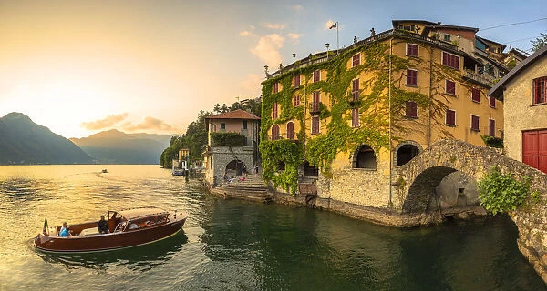 A boat of tourists stops to observe the sunset. Nesso, Province of Como, Como Lake