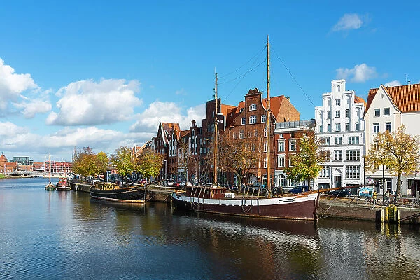 Boats anchored on Trave river and houses with traditional gables in background, Lubeck, UNESCO, Schleswig-Holstein, Germany