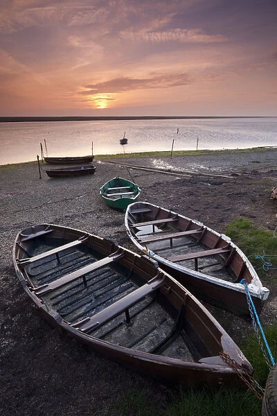 Boats at low tide on the shore of The Fleet lagoon, Chesil Beach, Dorset, England. Spring