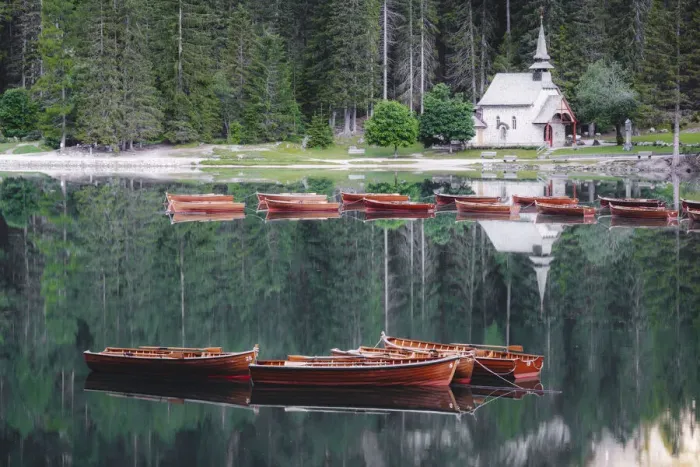 Framed Print : Boats in the pristine lake Braies (Pragser Wildsee) with the small chapel mirrored in