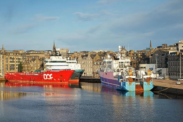 Boats at sea port with the City of Aberdeen, Aberdeen, Scotland, UK