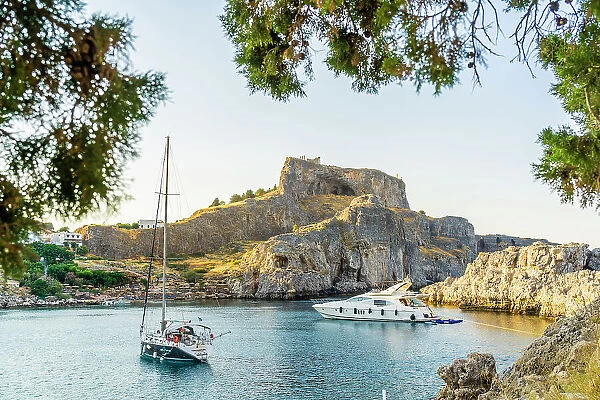 Boats at St Pauls Beach and The Acropolis of Lindos in the background, Lindos, Dodecanese Islands, Greece