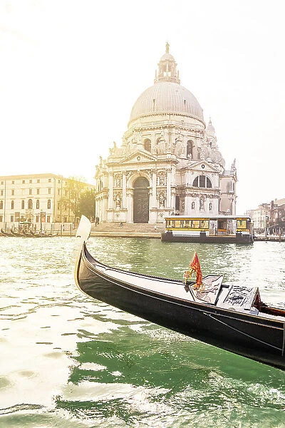 Bow of a gondola sailing in the Venetian Lagoon with Santa Maria della Salute Basilica on background, Venice, Veneto, Italy
