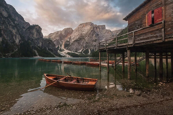 The Braies lake taking the first light of the day on a calm, cloudy summer morning. Dolomites, Italy