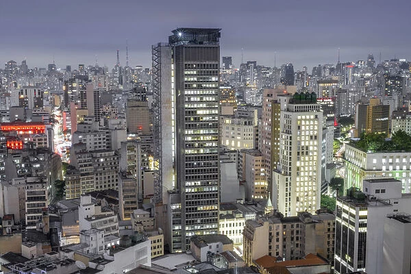 Brazil, Sao Paulo, Sao Paulo City, dense concrete and glass skyscrapers, corporate and residential buildings in the downtown city centre and central business district. Illuminated buildings, Night time shot