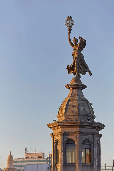 The bronze statue in homage to liberty of 'La Prensa'building (Beaux Arts) at sunset on Avenida de Mayo, Monserrat, Buenos Aires, Argentina. Once headquarters of the 'La Prensa'Daily Newspaper
