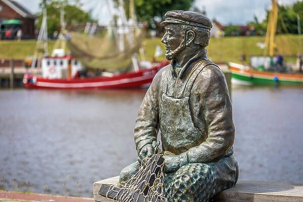Bronze statue Netzflicker (artist Hans-Christian Petersen) harbor of Greetsiel, East Frisia, Lower Saxony, Germany