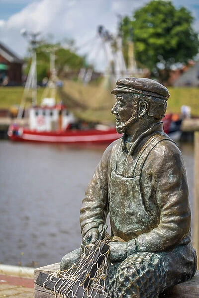 Bronze statue Netzflicker (artist Hans-Christian Petersen) harbor of Greetsiel, East Frisia, Lower Saxony, Germany