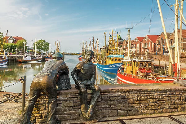 Bronze statues of fishermen in the harbor of Neuharlingersiel, East Frisia, Lower Saxony, Germany