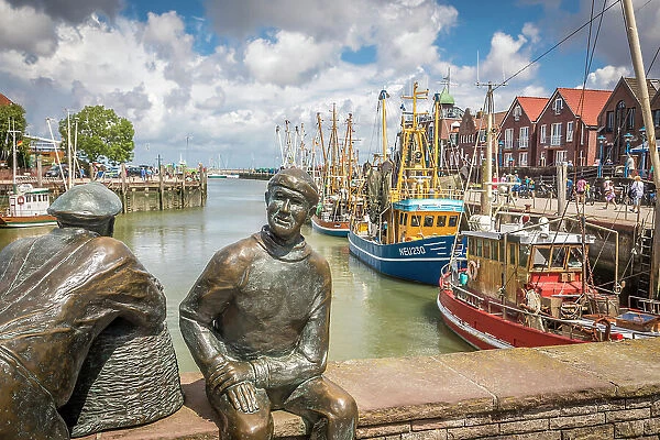 Bronze statues of fishermen in the harbor of Neuharlingersiel, East Frisia, Lower Saxony, Germany