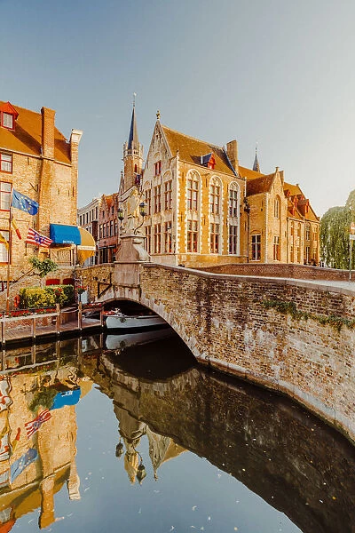 Bruges old city reflecting in the water canal at sunrise, Belgium