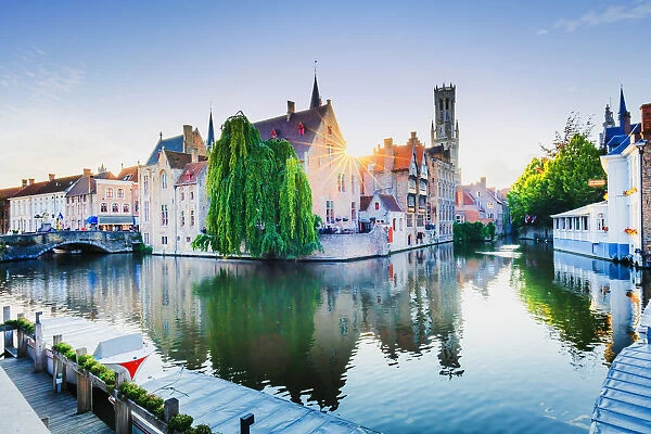 Bruges old town reflecting in the water canal at sunset, Belgium