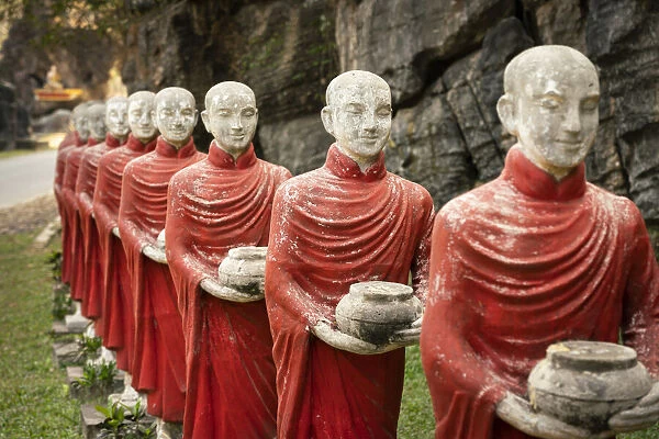 Many Buddhist monk statues standing in a row at Kaw Ka Thaung Cave, Hpa-an