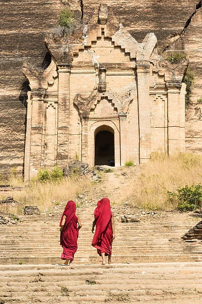 Buddhist novice monks walking by the Mingun Pahtodawgyi, unfinished monument stupa