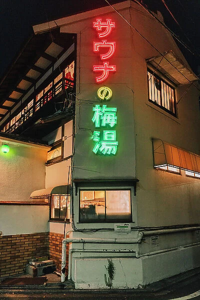 Building with neon signs at night in Kyoto, Japan