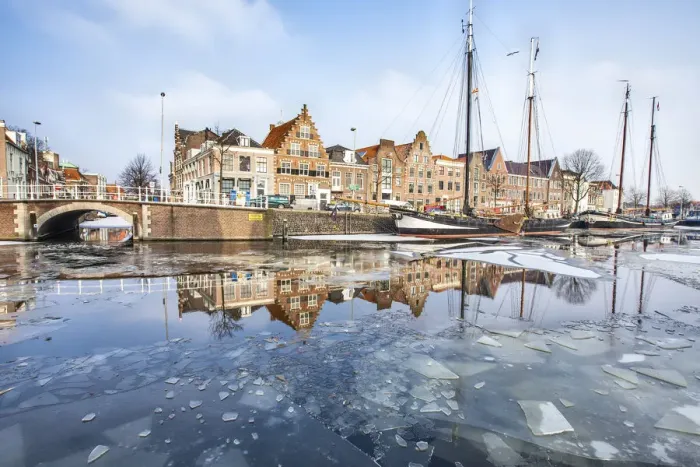 Framed Print : Buildings in Harleem reflecting in the half-frozen Spaarne River, Holland Framed Print : Buildings in Harleem reflecting in the half-frozen Spaarne River, Holland