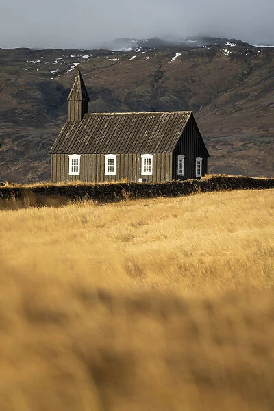 Buoakirkja Black Church on field against mountain in Budir, Snaefellsness Peninsula