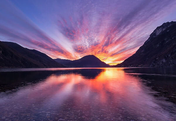 Burning sky at sunset over Lake Lugano, from shores of Lake Ceresio, Lombardy, Italy