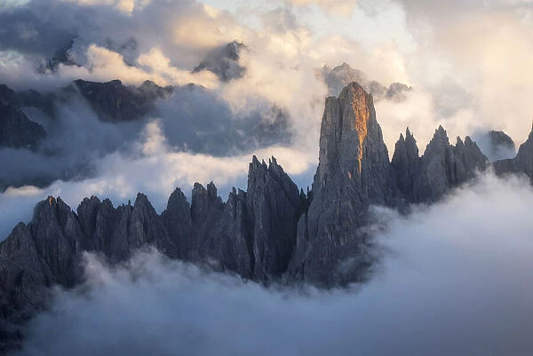 The Cadini di Misurina emerging from the sea of clouds during a stormy late summer sunset. Dolomites, Italy