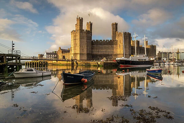 Caernarfon Castle reflected in the calm waters of the Afon Seiont, Caernarfon, North Wales, UK. Spring (May) 2023