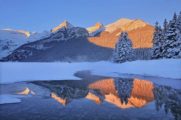 The Canadian Rocky Mountains reflected in Lake Louise at sunrise. Victoria Glacier on Mt. Victoria at left. Then from left to right is Mt. Whyte, The Big Beehive and Mt. Niblock and Mt. St. Piran. Banff National Park, Alberta, Canada